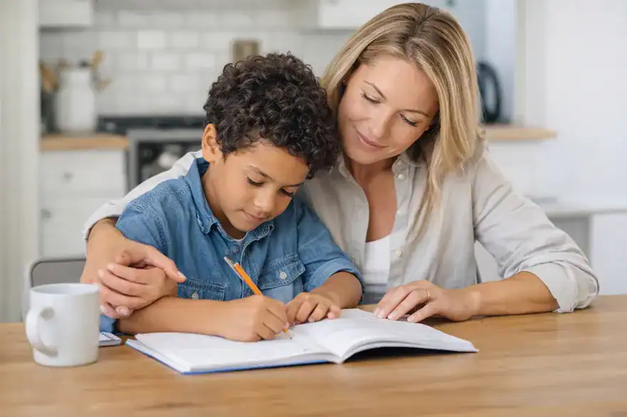 Mother with her son doing homework on the kitchen table